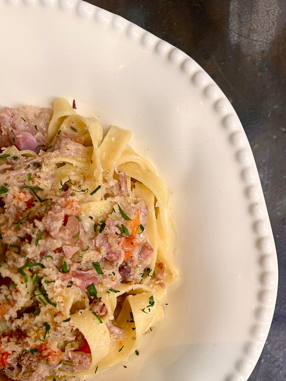 Pasta dish with a creamy sauce on a white plate